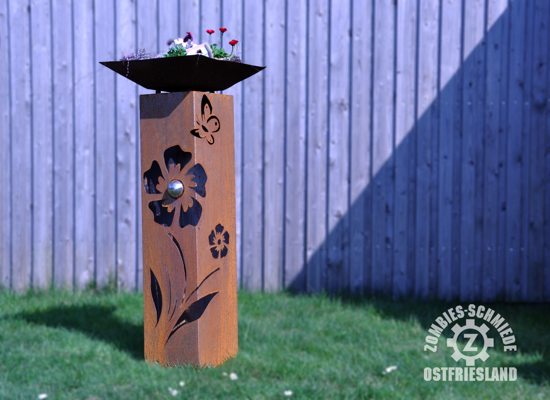 Rostsäule mit großer Blume und Kugel